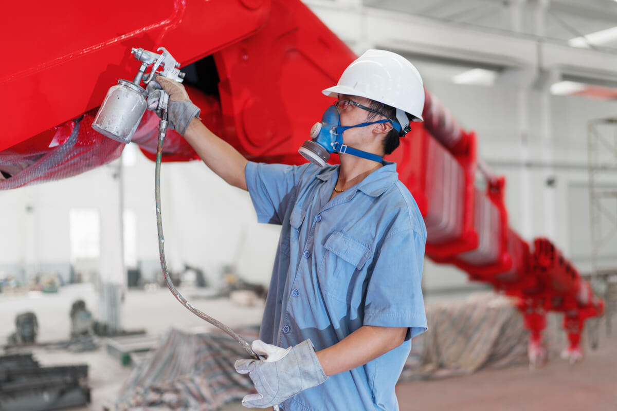 male-worker-spray-painting-a-crane-arm-red-in-fact-LNRSV8L.jpg